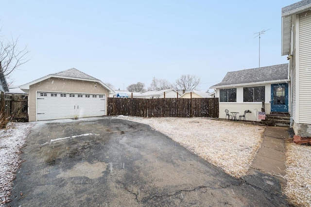 view of yard with a garage, entry steps, an outdoor structure, and fence