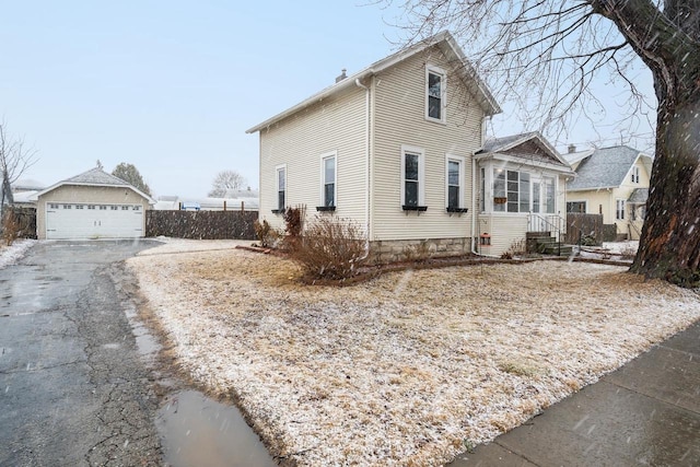 view of front of home featuring a garage and an outbuilding