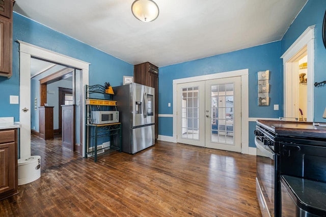 kitchen with baseboards, range with electric cooktop, dark wood-type flooring, french doors, and stainless steel refrigerator with ice dispenser