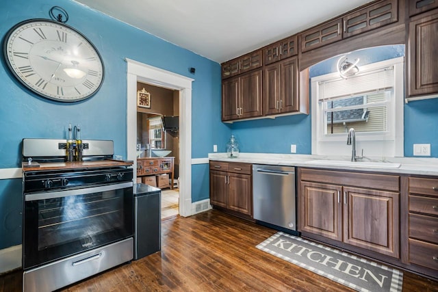 kitchen featuring dark wood-style floors, appliances with stainless steel finishes, and a sink