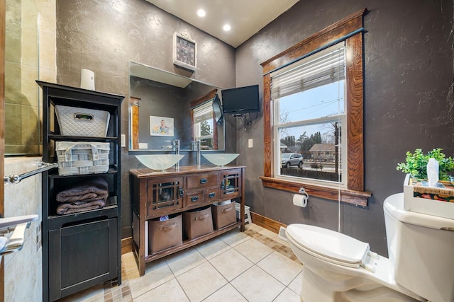 bathroom with tile patterned flooring, double vanity, toilet, and baseboards