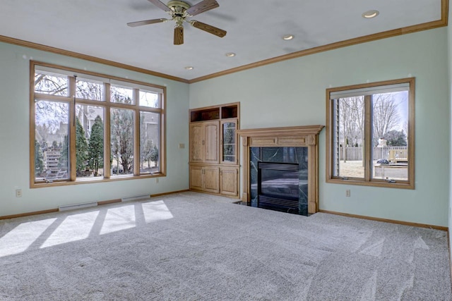 unfurnished living room with plenty of natural light, carpet flooring, and baseboards