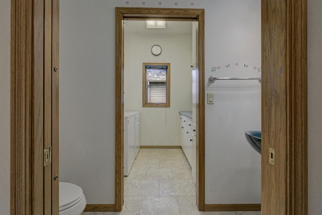 bathroom with vanity, baseboards, washing machine and clothes dryer, tile patterned floors, and toilet