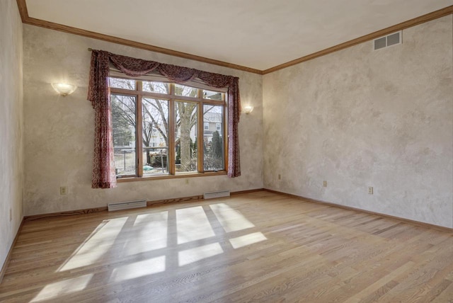 empty room with crown molding, plenty of natural light, wood finished floors, and visible vents