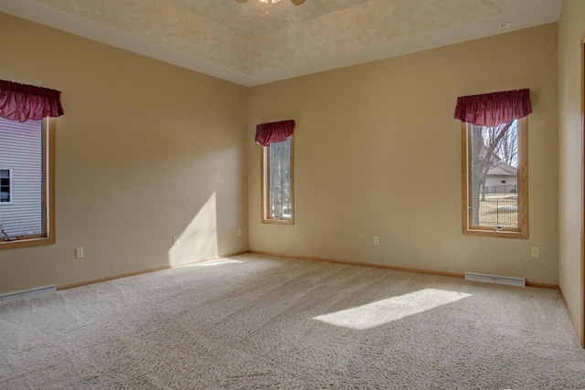 spare room with visible vents, baseboards, carpet floors, ceiling fan, and a raised ceiling