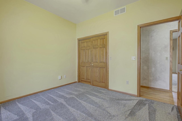 unfurnished bedroom with visible vents, carpet flooring, and baseboards