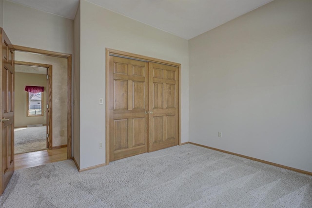 unfurnished bedroom with a closet, baseboards, and carpet