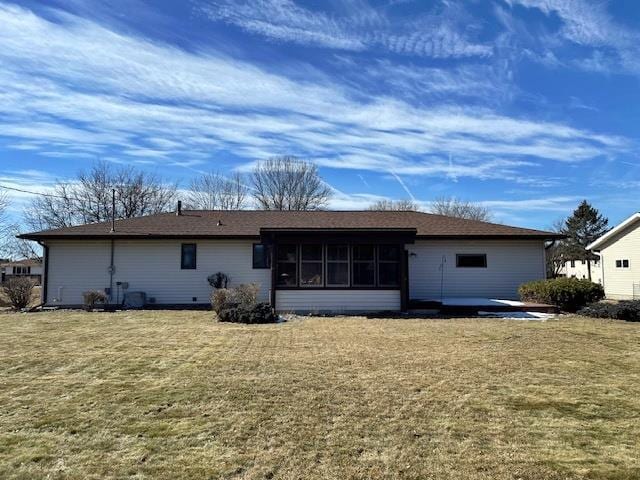 back of property featuring a lawn and a sunroom