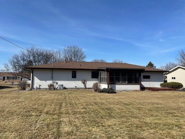 back of house featuring a yard and a sunroom