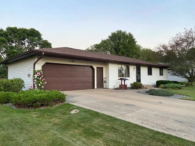 ranch-style house with an attached garage, concrete driveway, and a front yard