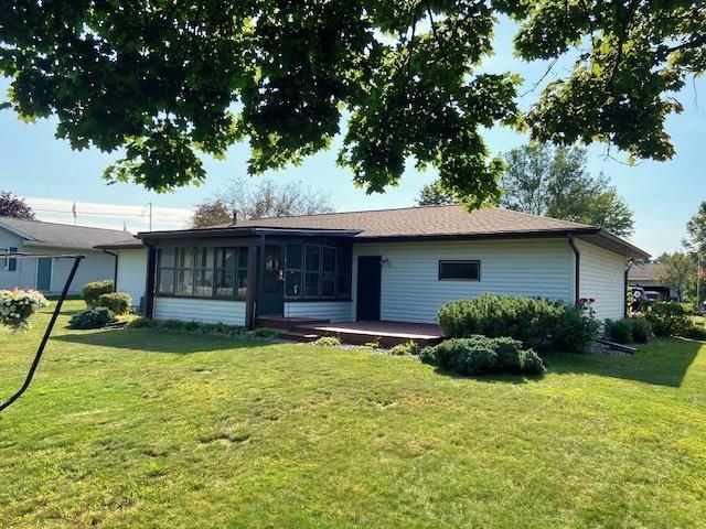 back of house with a lawn and a sunroom