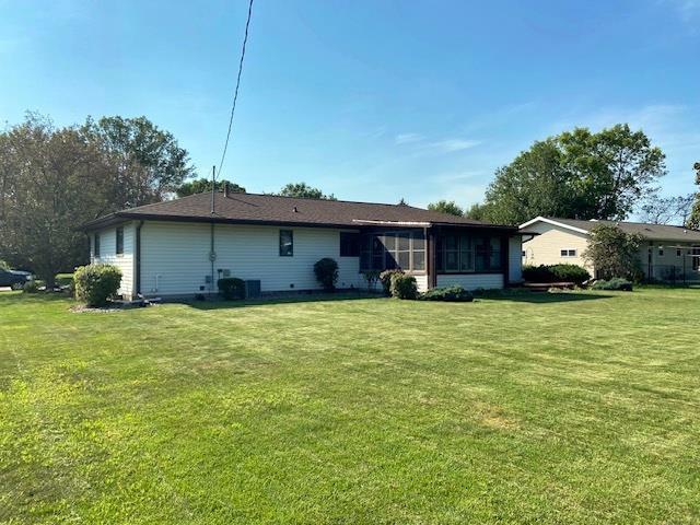 back of property with a yard and a sunroom