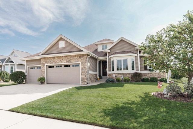 784 Westbridge Trl, Waunakee, WI 53597 - view of front of property with a front yard, driveway, a shingled roof, stone siding, and a garage