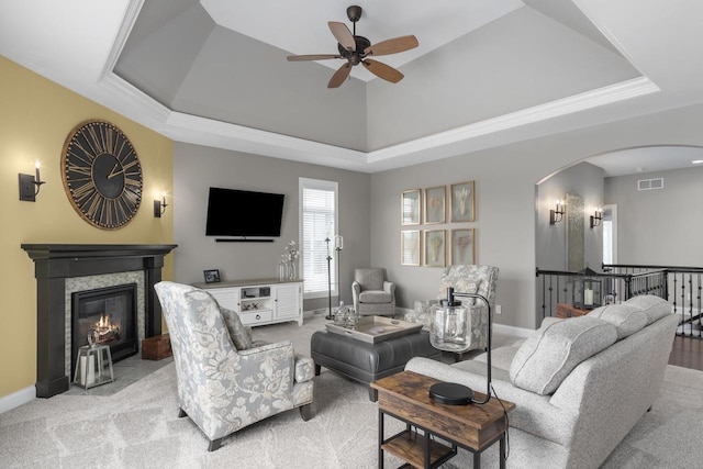 784 Westbridge Trl, Waunakee, WI 53597 - living room featuring visible vents, arched walkways, light carpet, a glass covered fireplace, and a raised ceiling