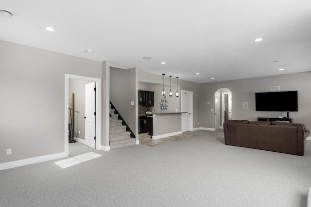 784 Westbridge Trl, Waunakee, WI 53597 - living room featuring baseboards, recessed lighting, arched walkways, stairs, and light colored carpet