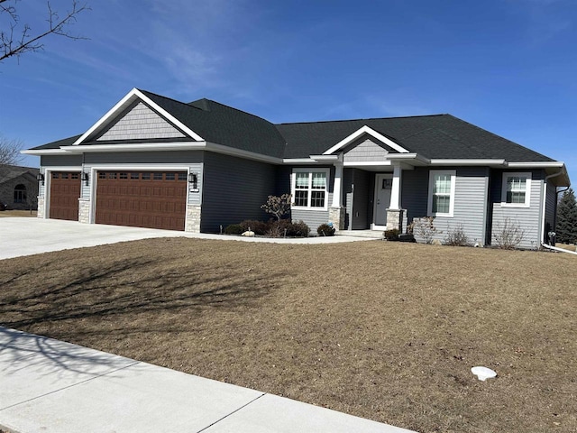 view of front facade featuring a garage, stone siding, concrete driveway, and a front yard