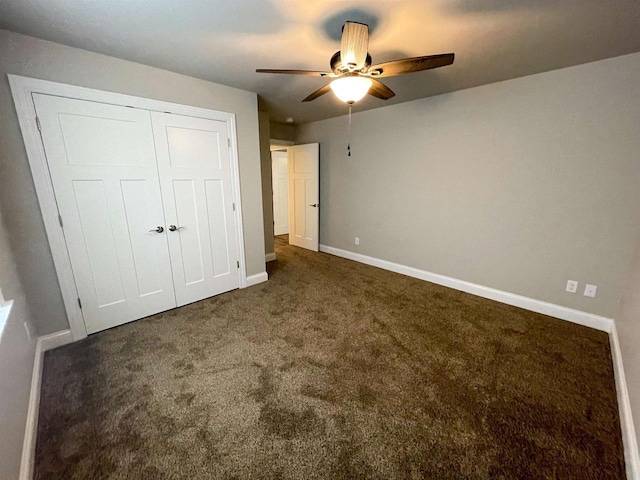 unfurnished bedroom with carpet flooring, baseboards, a closet, and ceiling fan