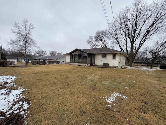 back of property featuring cooling unit, a lawn, and a sunroom