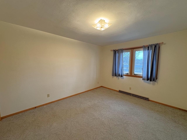 spare room featuring a textured ceiling, light carpet, baseboards, and a baseboard radiator