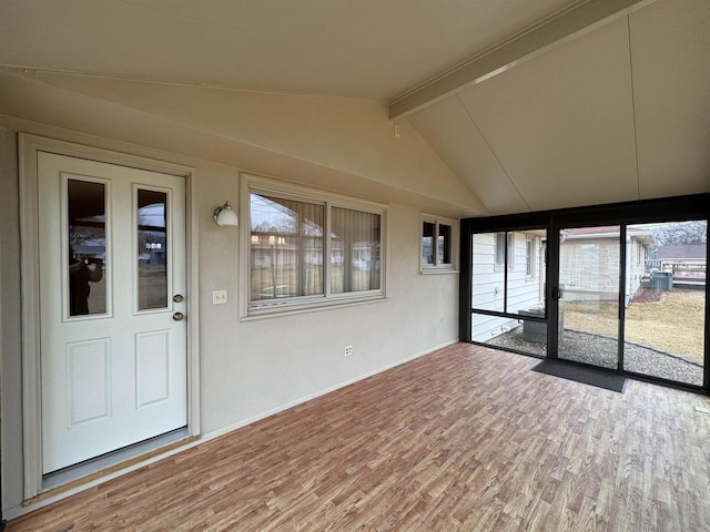 unfurnished sunroom featuring vaulted ceiling with beams