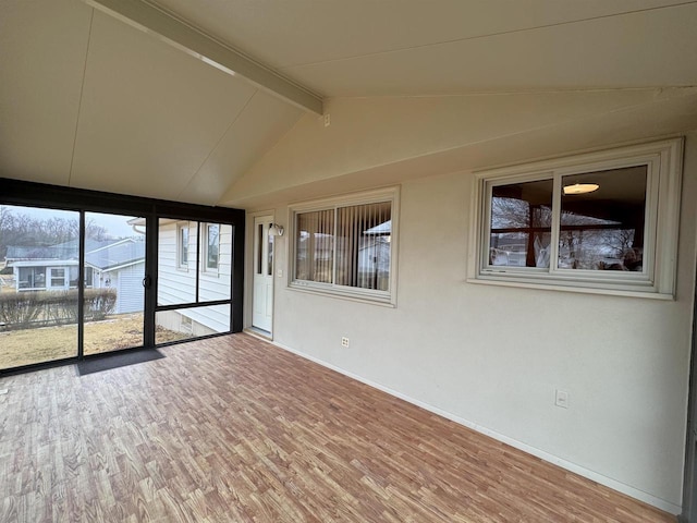 unfurnished sunroom with lofted ceiling with beams