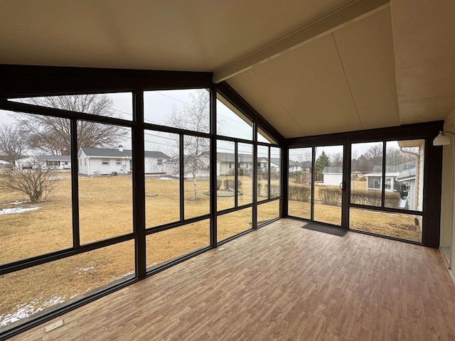 unfurnished sunroom with vaulted ceiling with beams