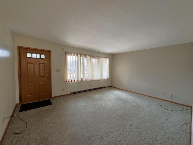 foyer featuring a baseboard heating unit, light colored carpet, and baseboards