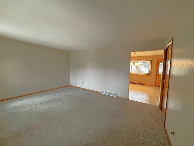 spare room with visible vents, baseboards, light carpet, baseboard heating, and an inviting chandelier