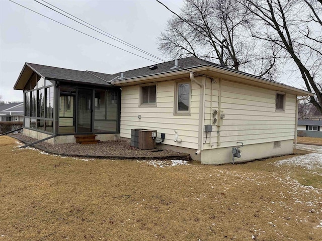 back of house featuring crawl space, central air condition unit, a lawn, and a sunroom