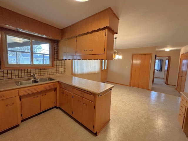 kitchen featuring tasteful backsplash, light floors, light countertops, and a sink