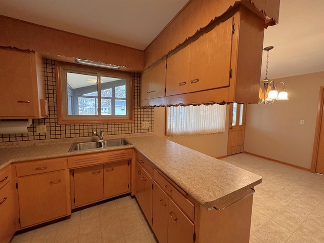 kitchen featuring a sink, decorative backsplash, light floors, and light countertops