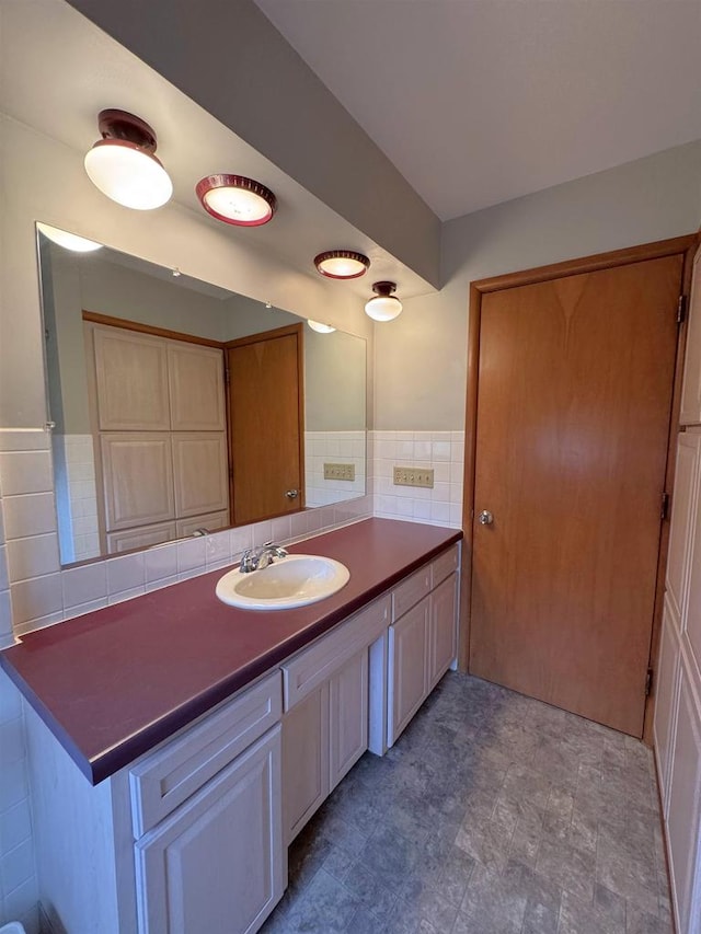 bathroom with vanity and tile walls