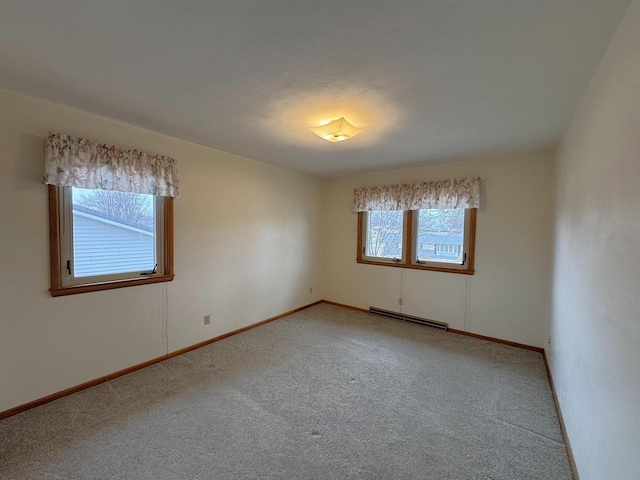 unfurnished room with baseboards, baseboard heating, and light carpet