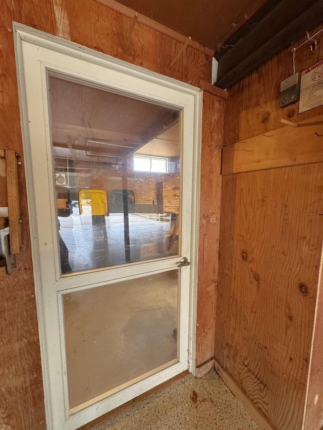 interior space with speckled floor and wooden walls