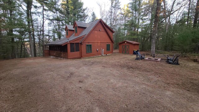W3864 W Lemonweir Ct, Mauston, WI 53948 - view of property exterior with an outdoor structure, a storage shed, and log exterior