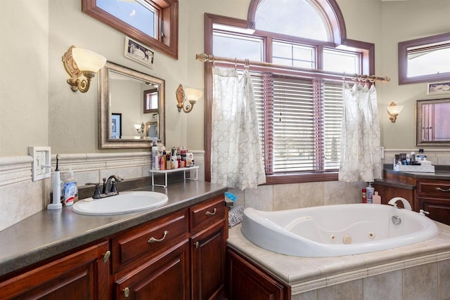 full bathroom featuring a jetted tub, a healthy amount of sunlight, and vanity