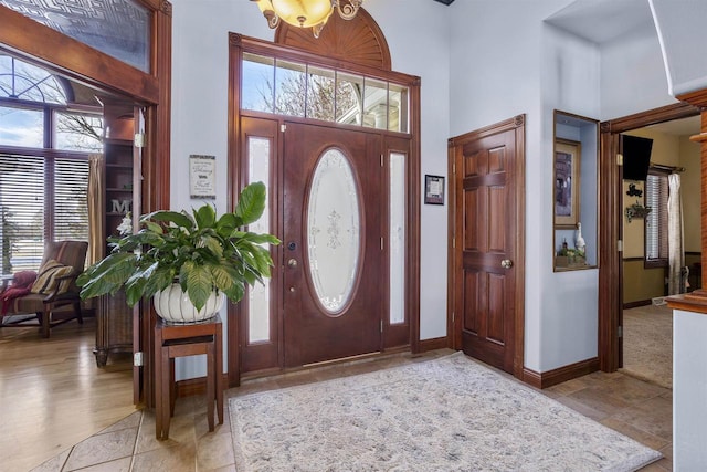 foyer with baseboards and a high ceiling