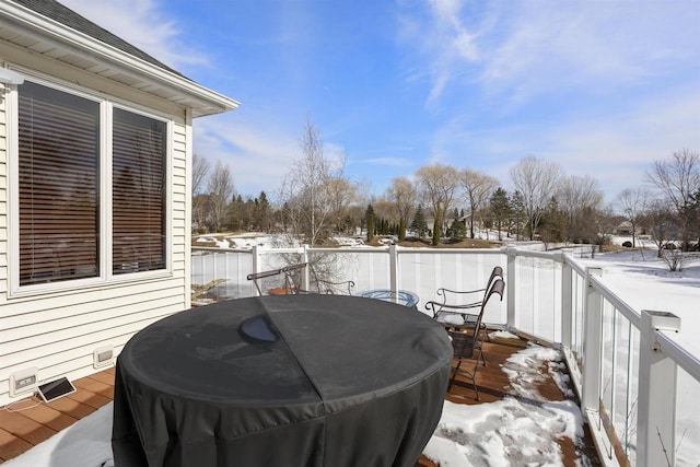 snow covered deck featuring outdoor dining area and area for grilling