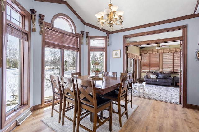 dining space featuring light wood-type flooring, visible vents, baseboards, crown molding, and lofted ceiling