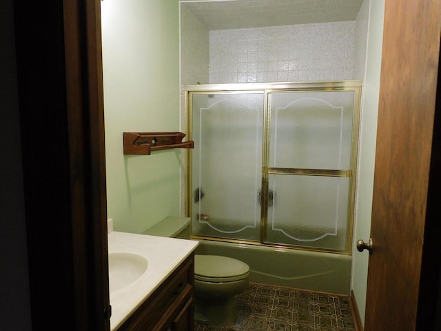 bathroom featuring toilet, vanity, and bath / shower combo with glass door