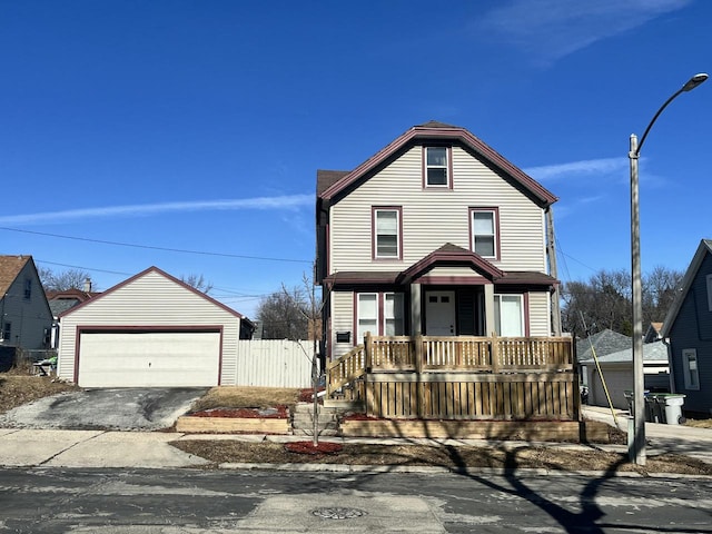 view of front of property featuring an outbuilding, covered porch, a garage, and fence