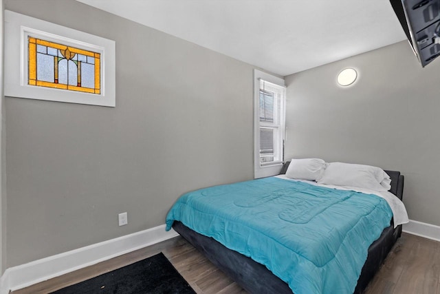 bedroom featuring baseboards and wood finished floors