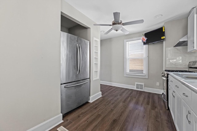 kitchen with under cabinet range hood, dark wood-style floors, baseboards, and appliances with stainless steel finishes