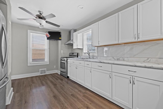 kitchen featuring stainless steel gas range oven, backsplash, white cabinetry, and a sink