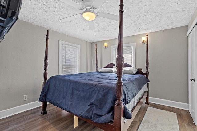 bedroom with a textured ceiling, wood finished floors, baseboards, and ceiling fan