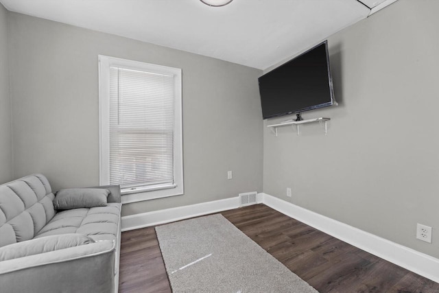 living room featuring visible vents, baseboards, and dark wood-style flooring