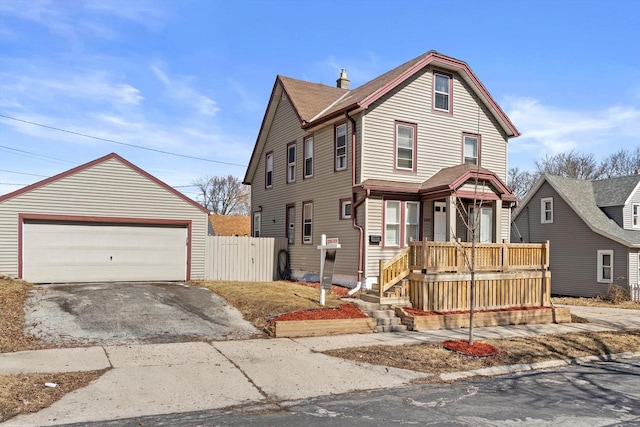 view of front of home with an outbuilding, a detached garage, and fence