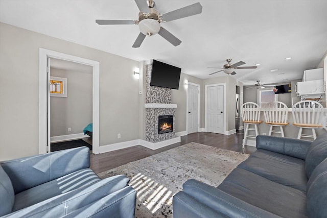 living room featuring a fireplace, wood finished floors, and baseboards