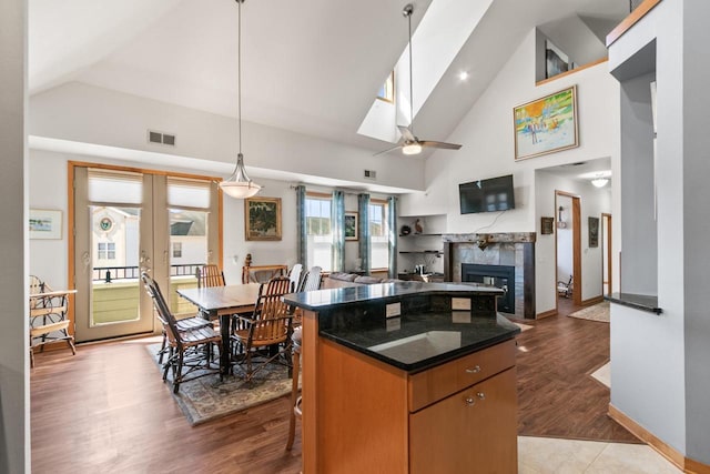 kitchen with visible vents, a center island, a fireplace, a skylight, and light wood-style floors