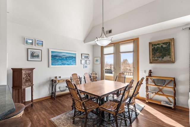 dining space with visible vents, wood finished floors, baseboards, and vaulted ceiling